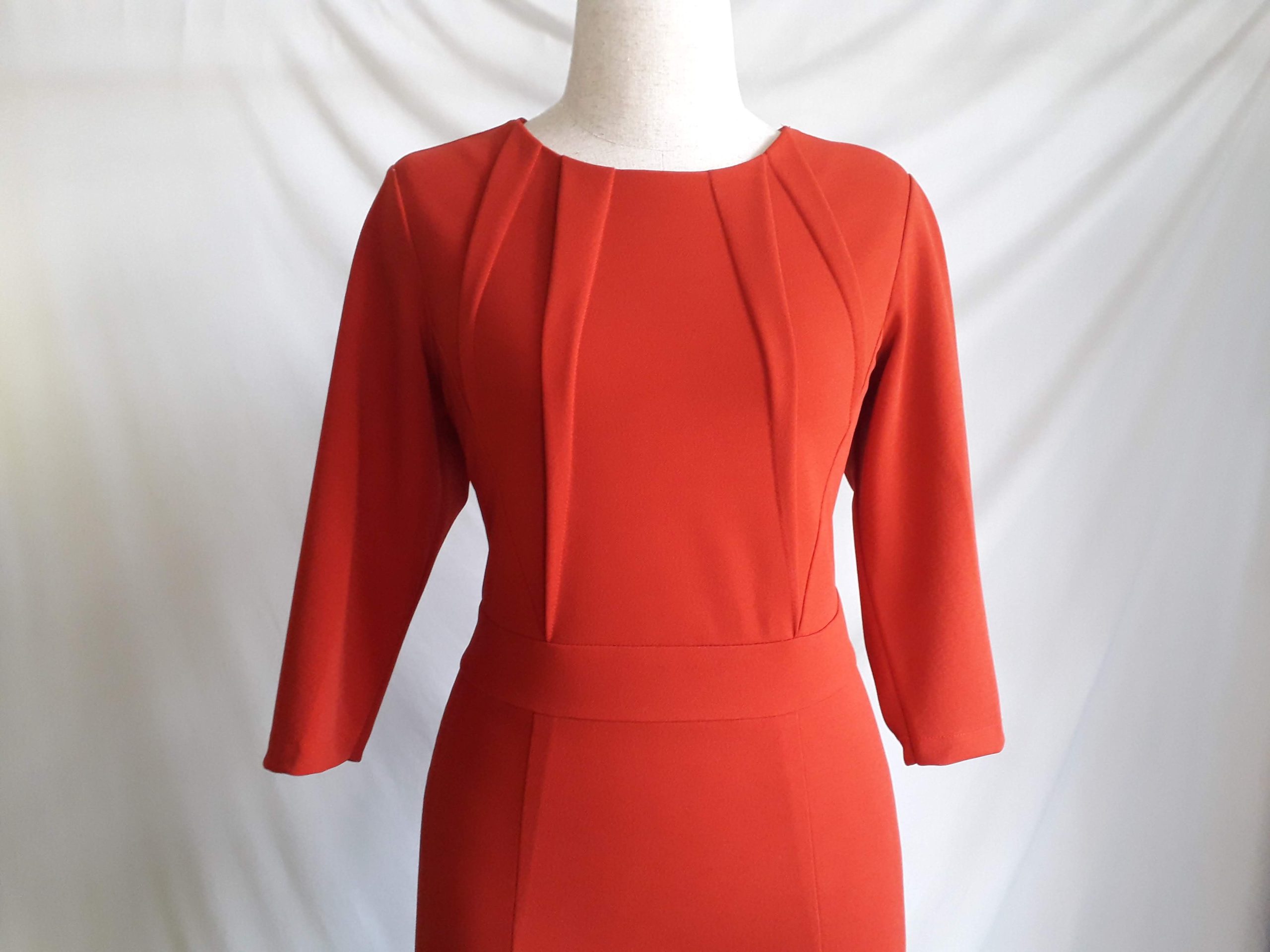 Robe rouge à plis sur mannequin blanc