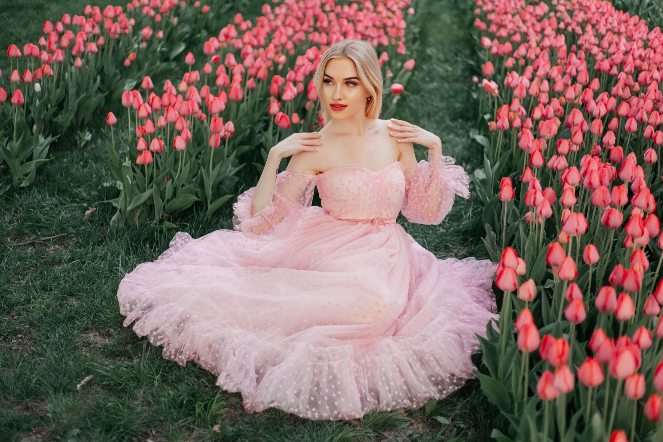 Femme en robe rose dans champ de tulipes