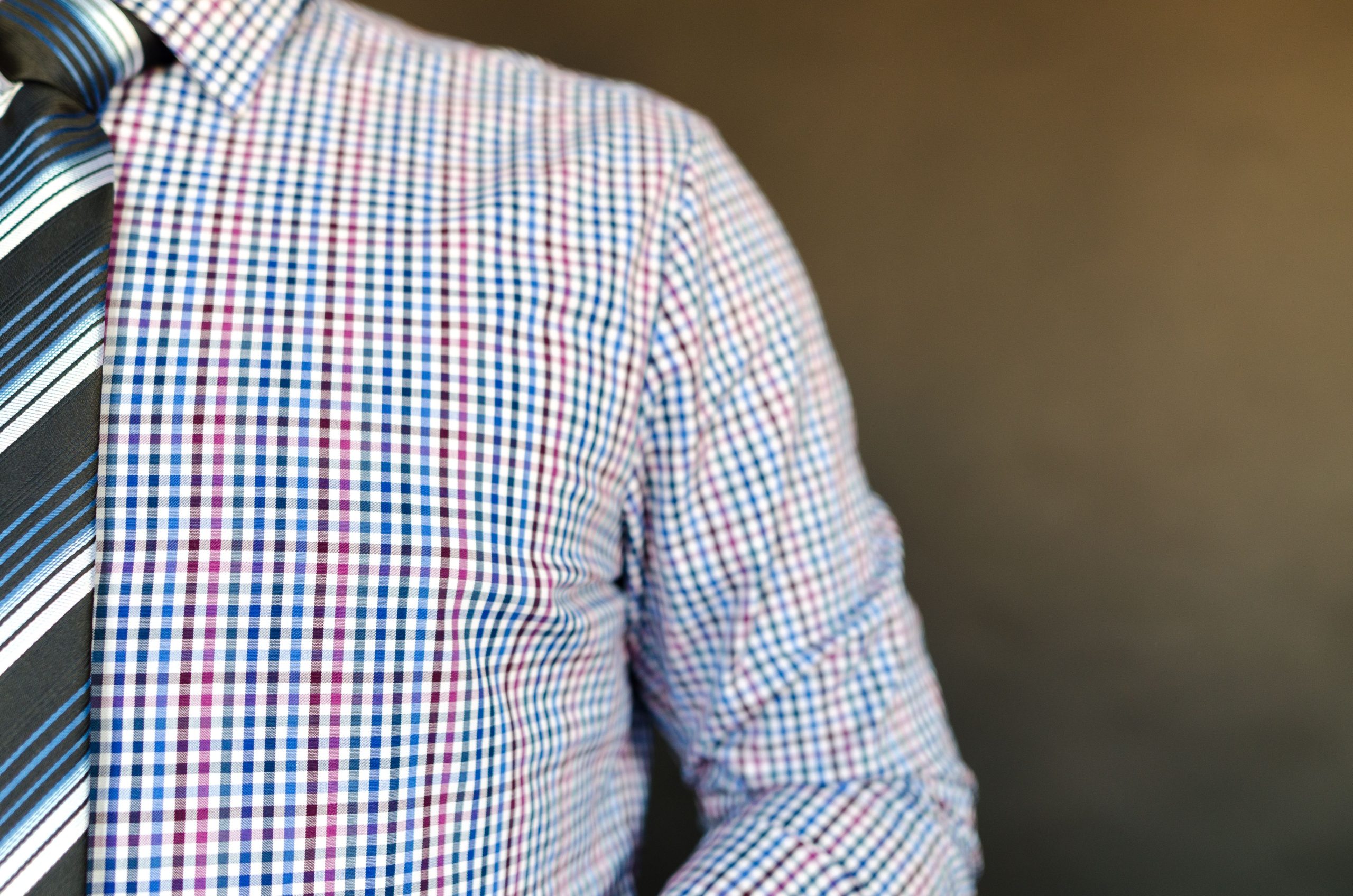 Homme élégant portant chemise carreaux et cravate rayée