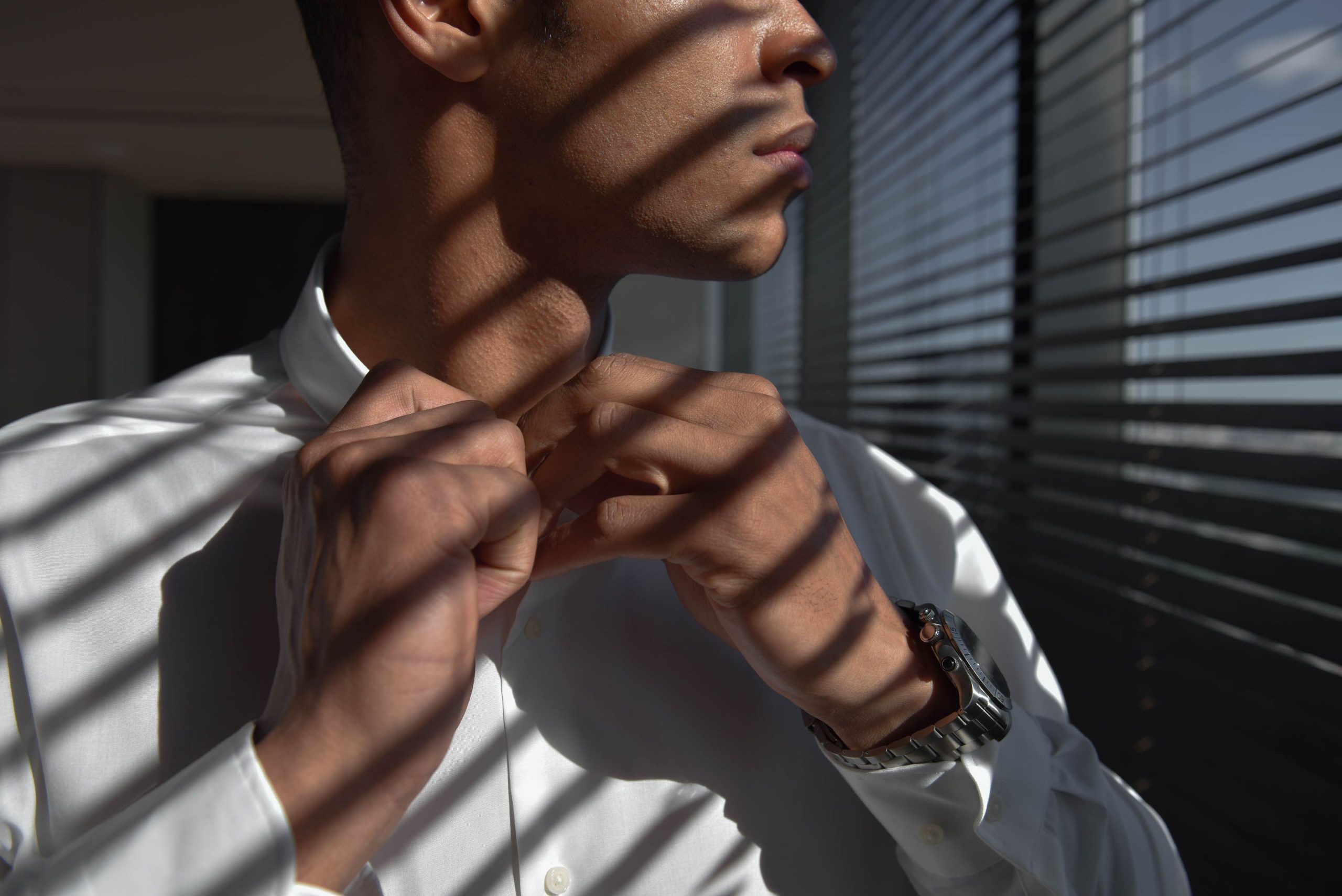 Homme arrangeant sa chemise avec lumière naturelle