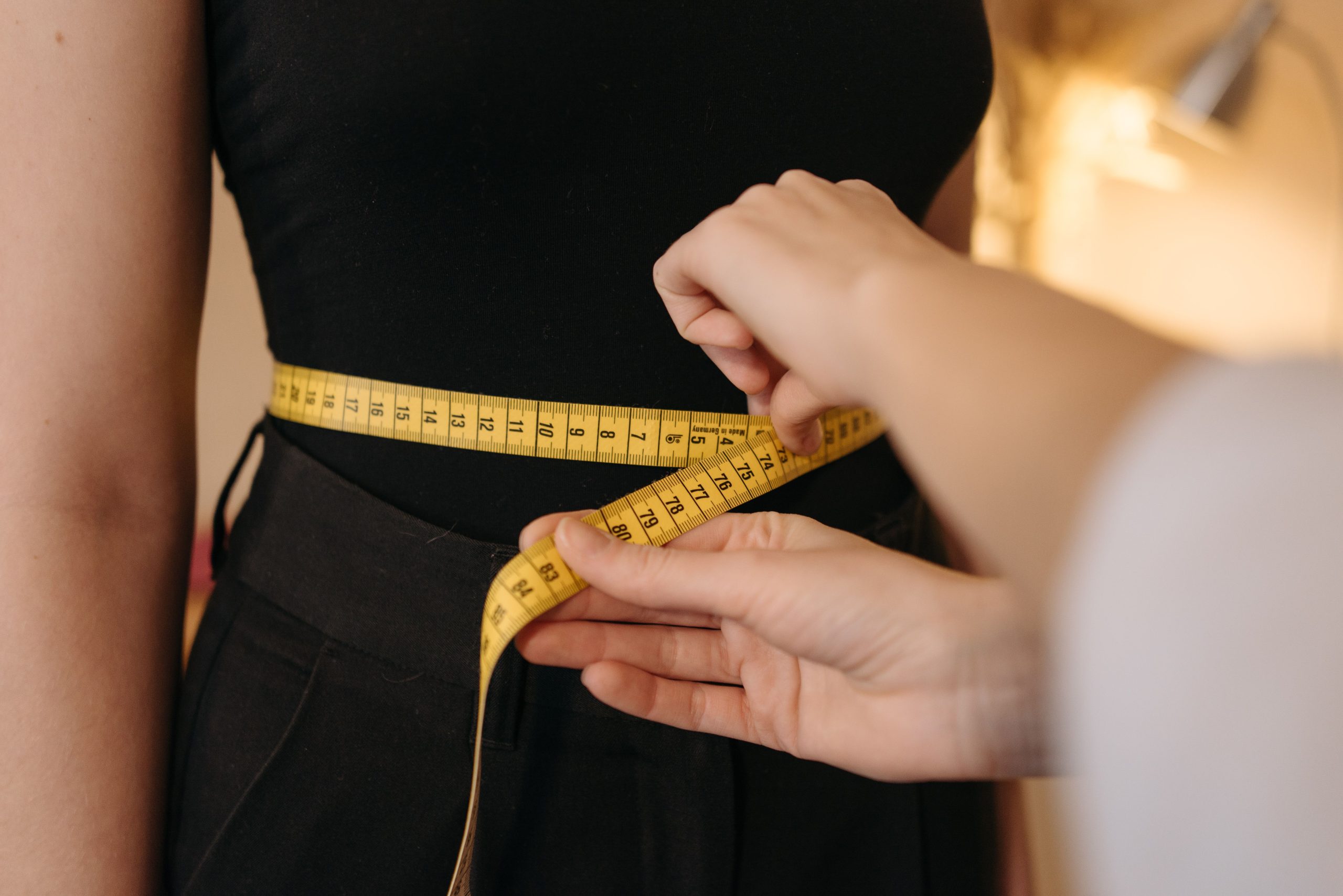 Mains de couturière mesurant la taille