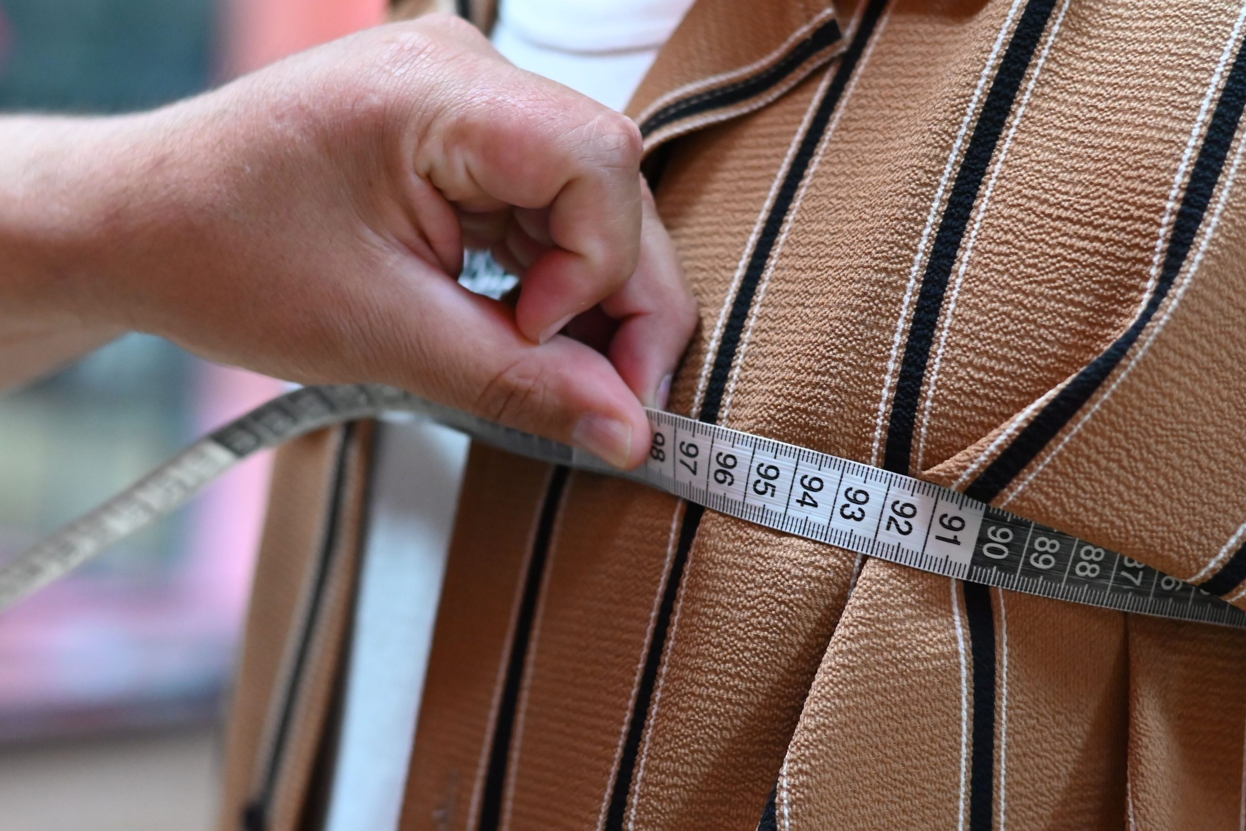 Artisan mesure tissu avec méticulosité