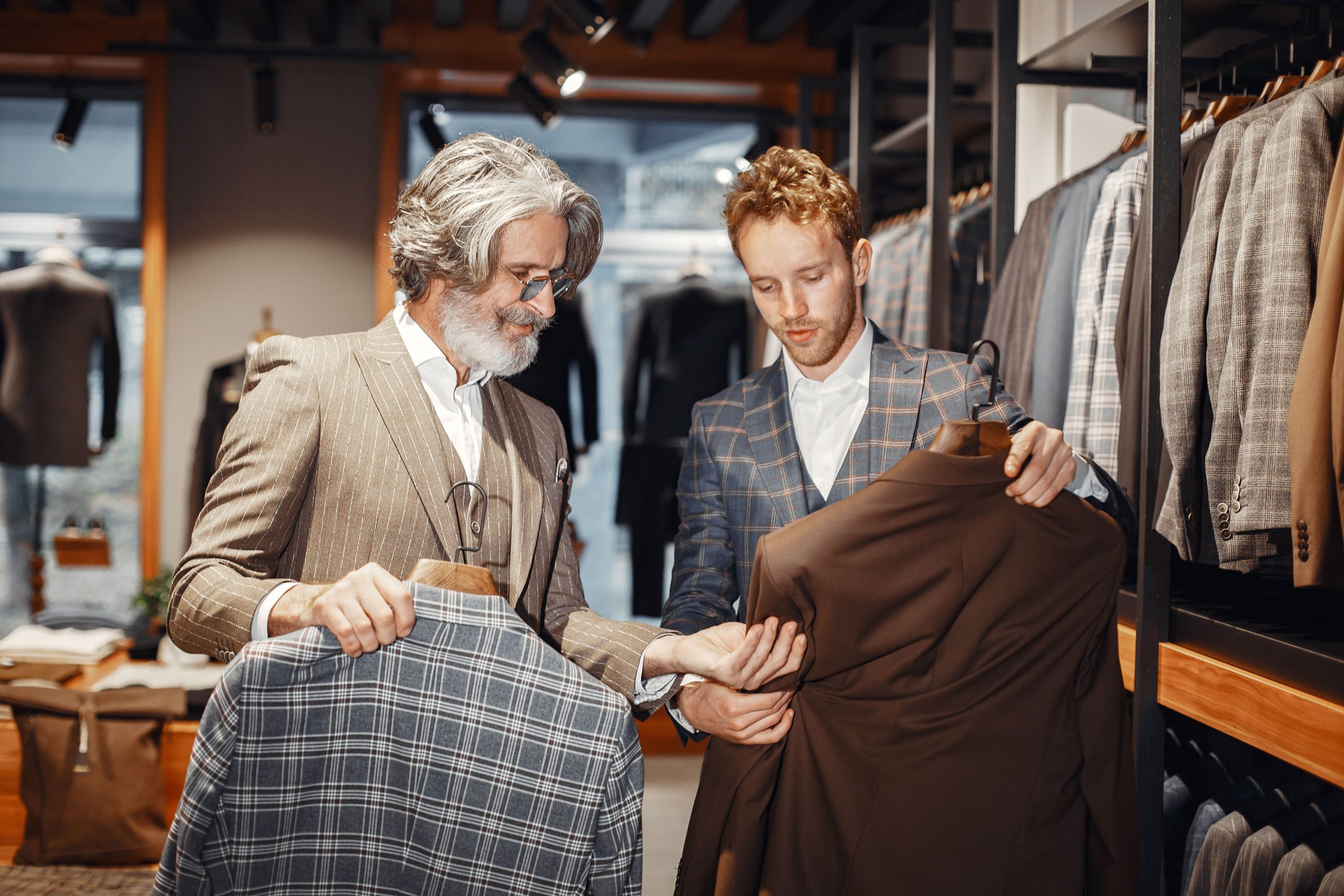 Hommes sélectionnent costumes dans boutique moderne