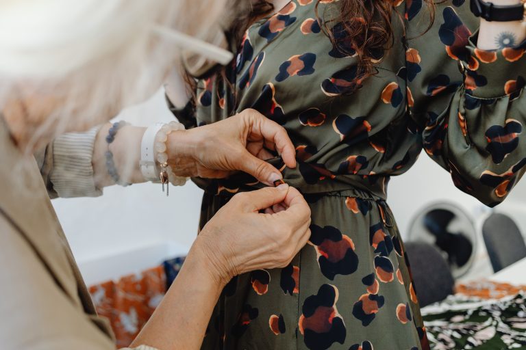 Couturière ajuste une robe à la taille