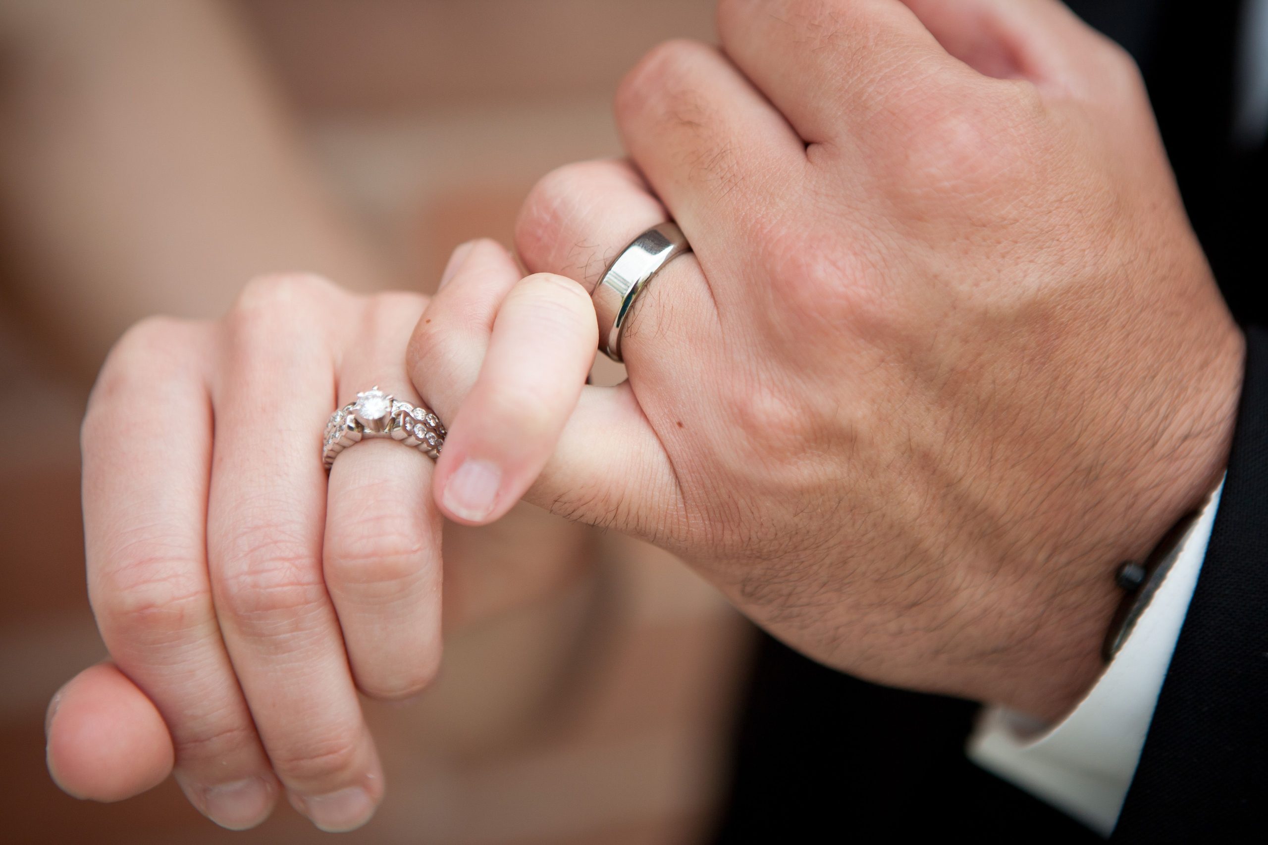Mains enlacées couple portant alliances engagement mariage