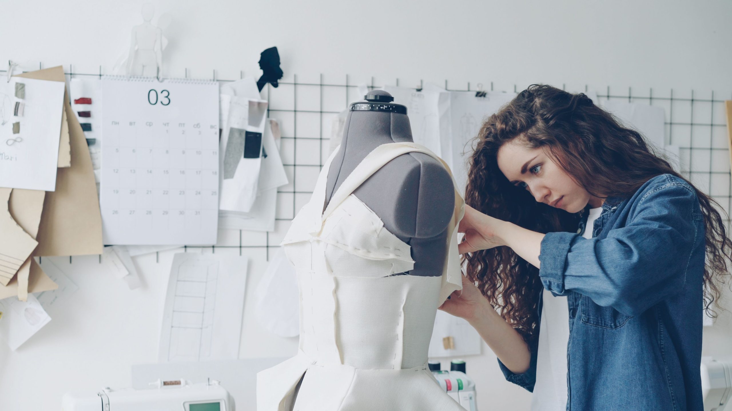 Jeune designer confectionnant robe en studio créatif