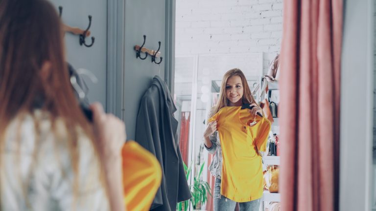Femme admire un top jaune en boutique