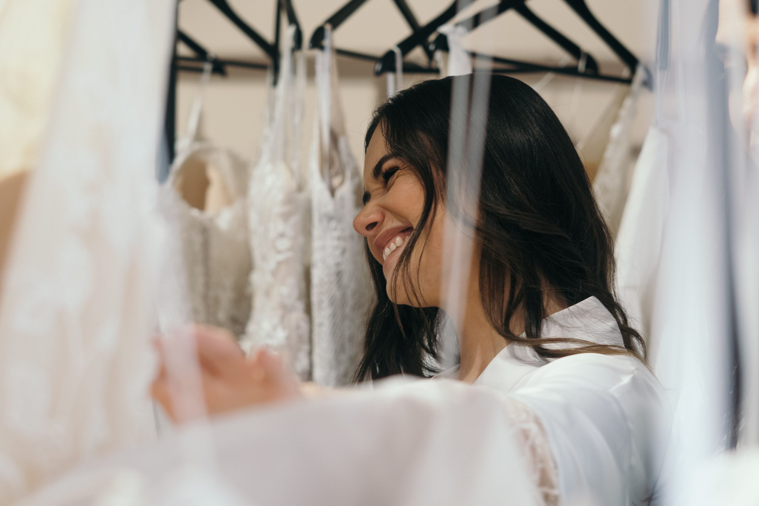 Femme souriante essayant robe de mariée