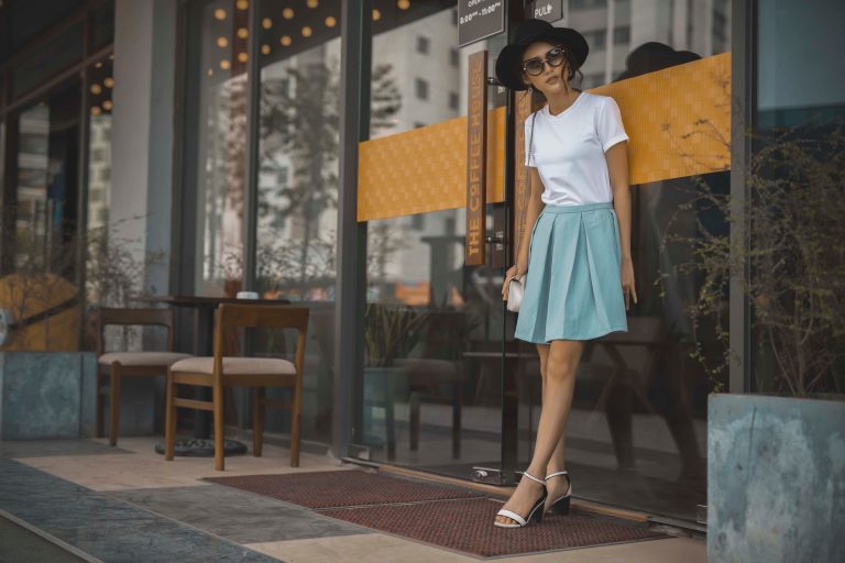 Femme en chemise blanche et jupe bleue plissée