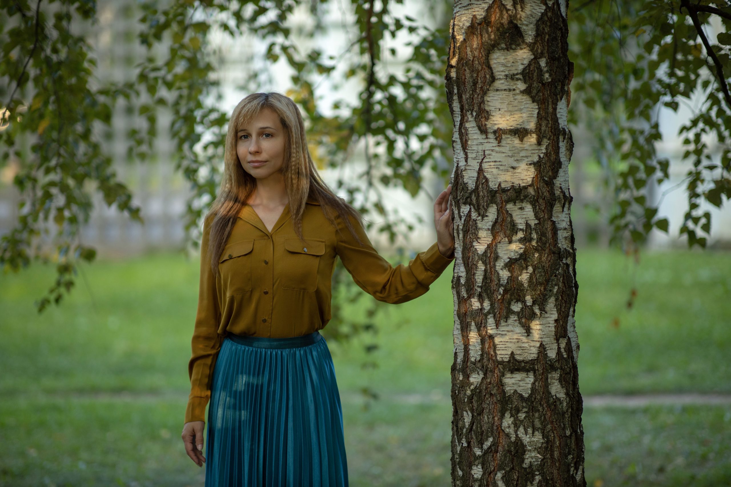 Femme en jupe bleue et chemisier jaune en parc