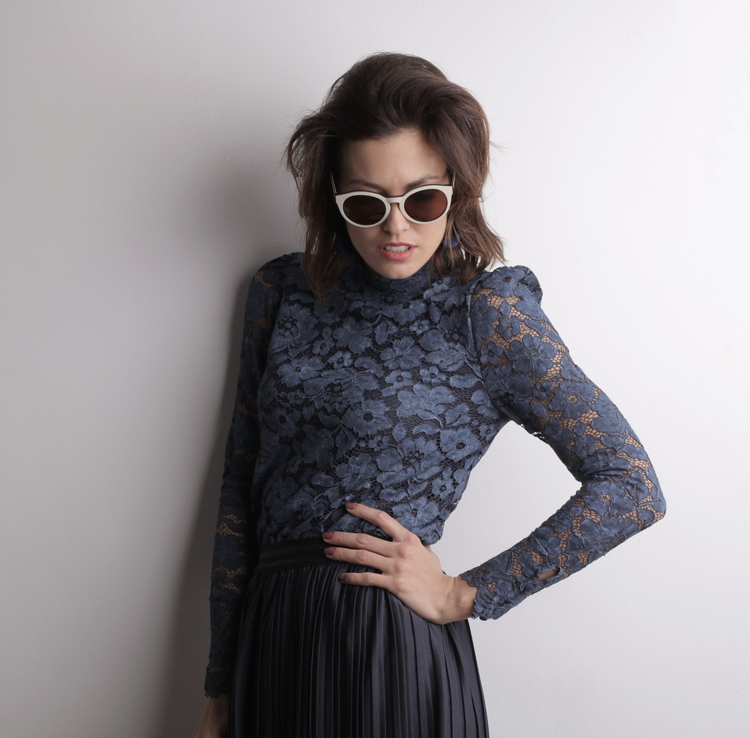 Femme élégante en top dentelle et lunettes soleil