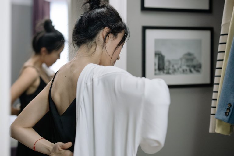 Femme essayant des vêtements en cabine moderne
