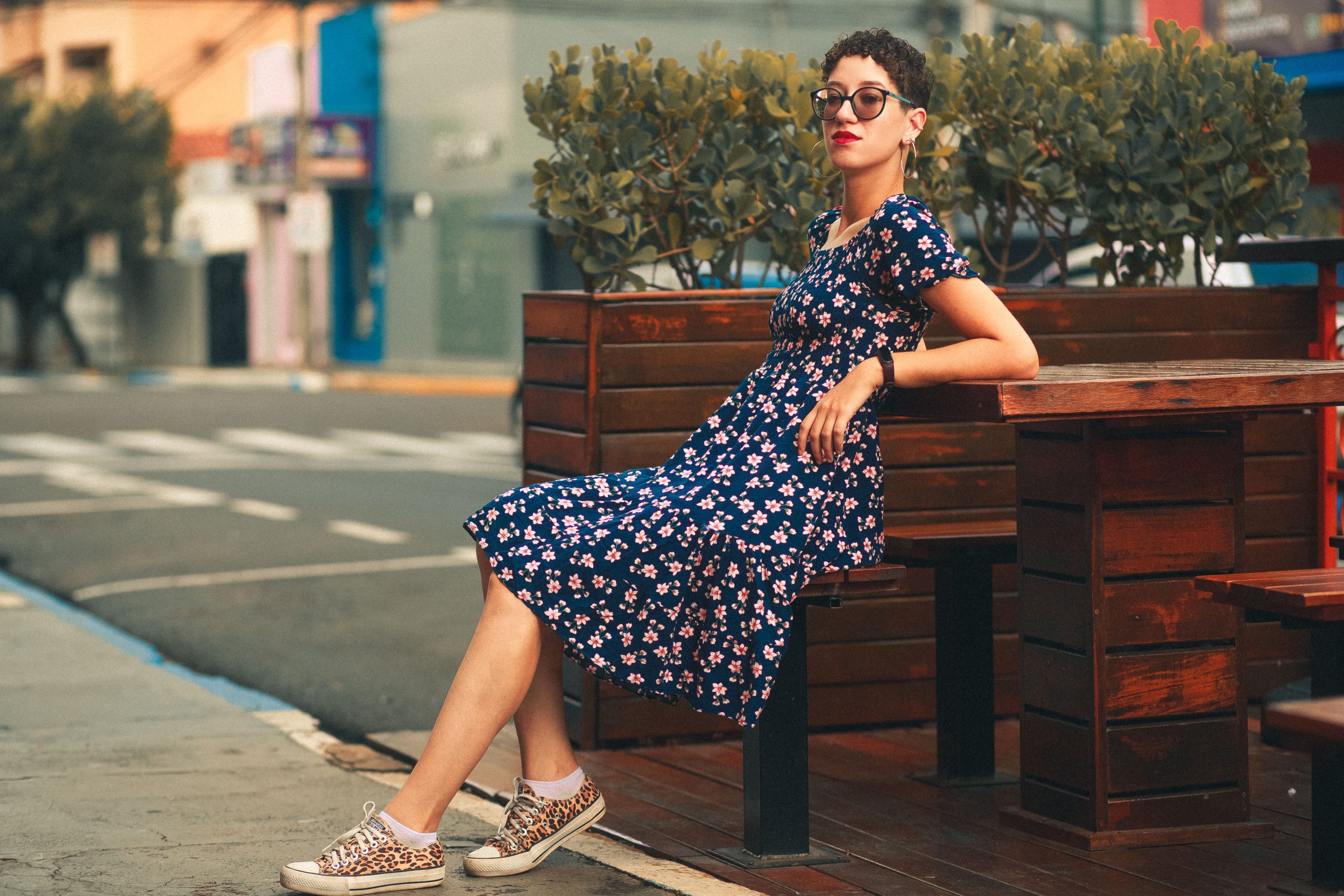 Femme tendance en robe fleurie à la terrasse