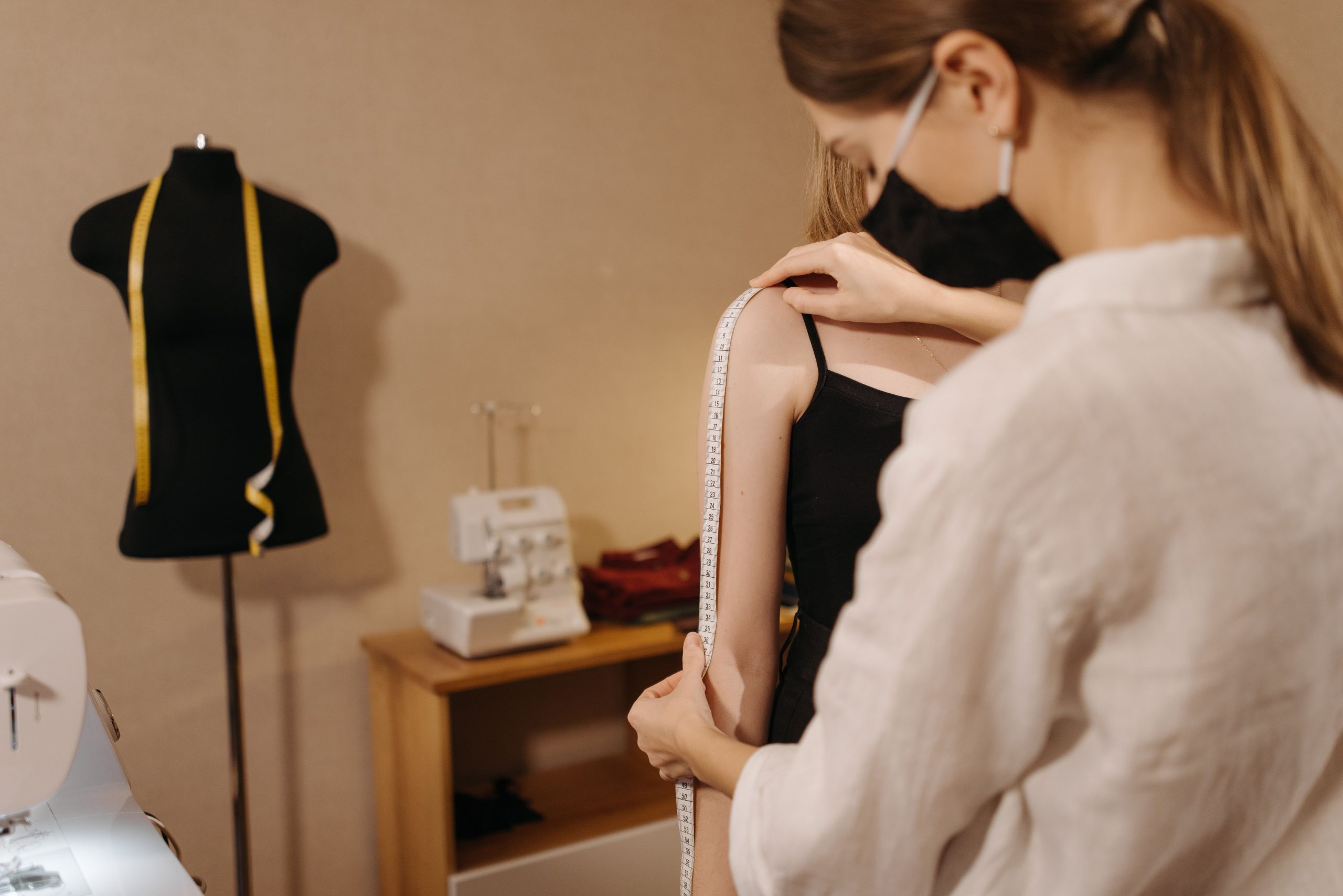 Styliste mesurant l'épaule client en studio
