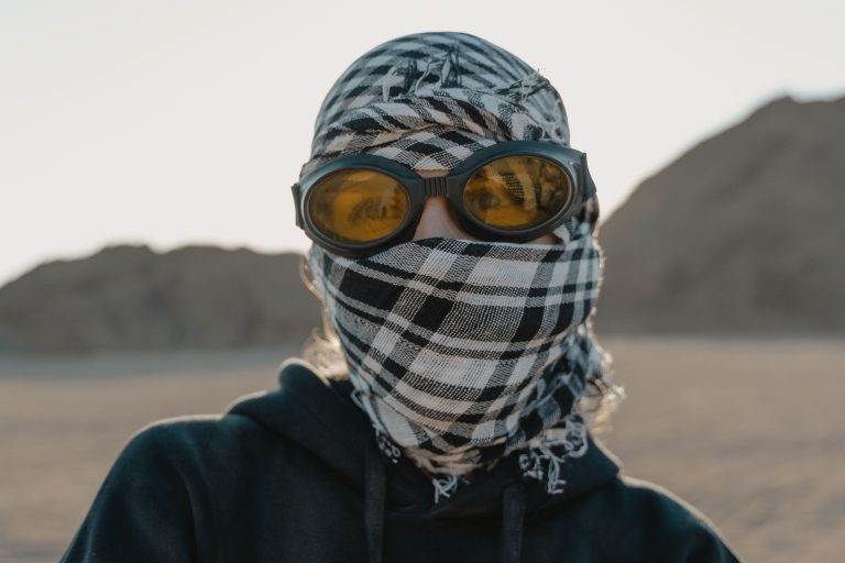 Personne au désert avec lunettes et foulard de protection