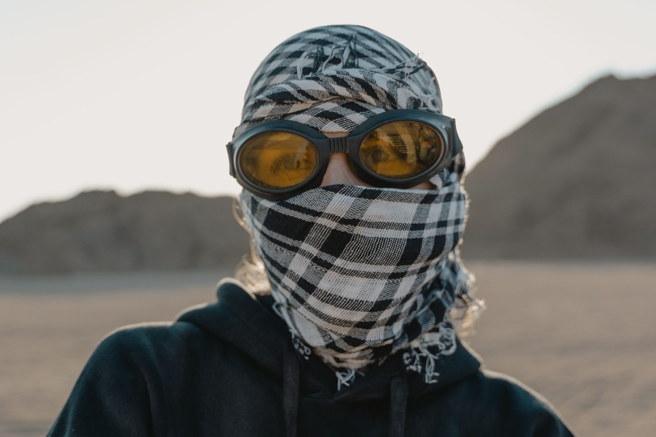 Personne au désert avec lunettes et foulard de protection