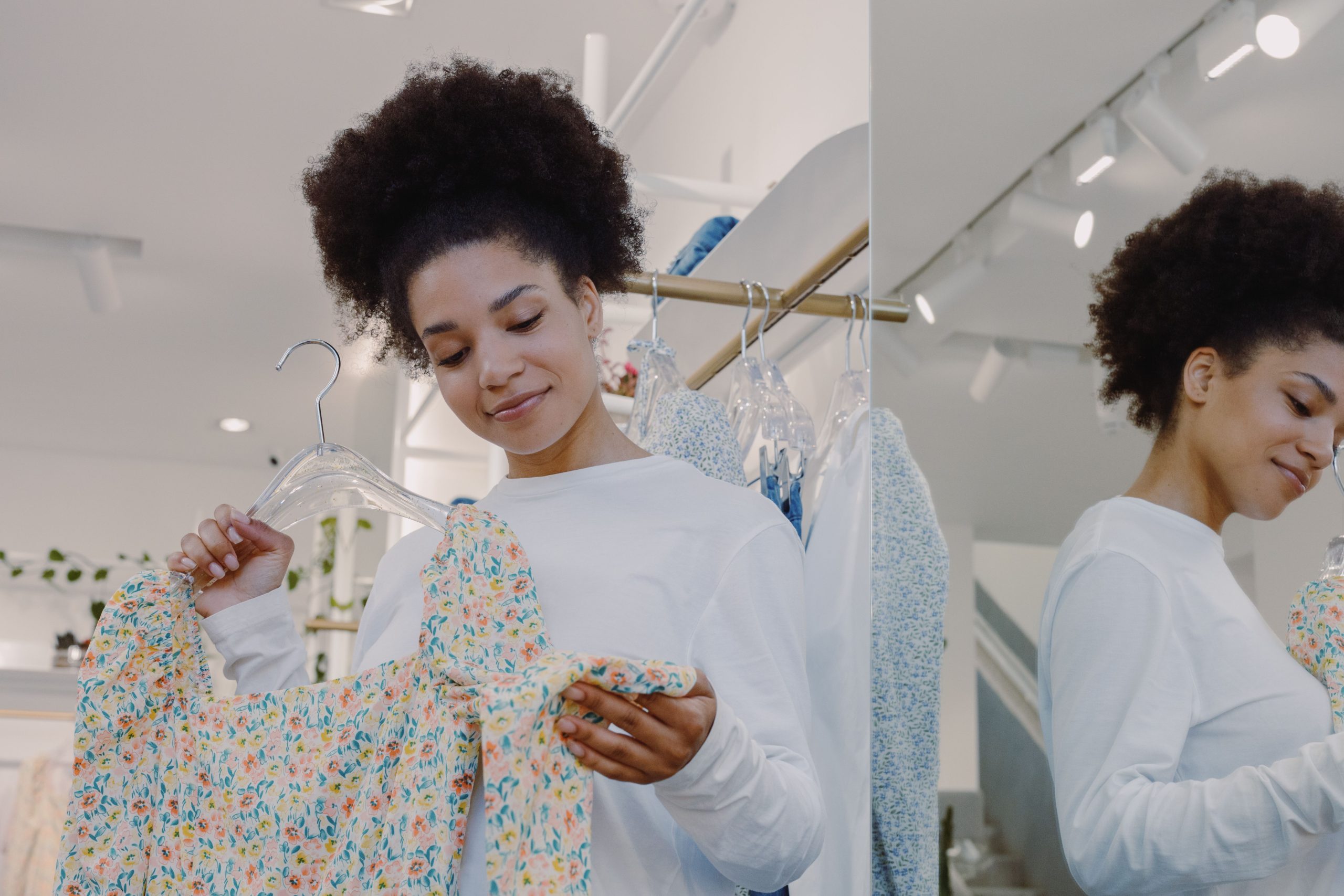 Femme examine un top fleuri en boutique