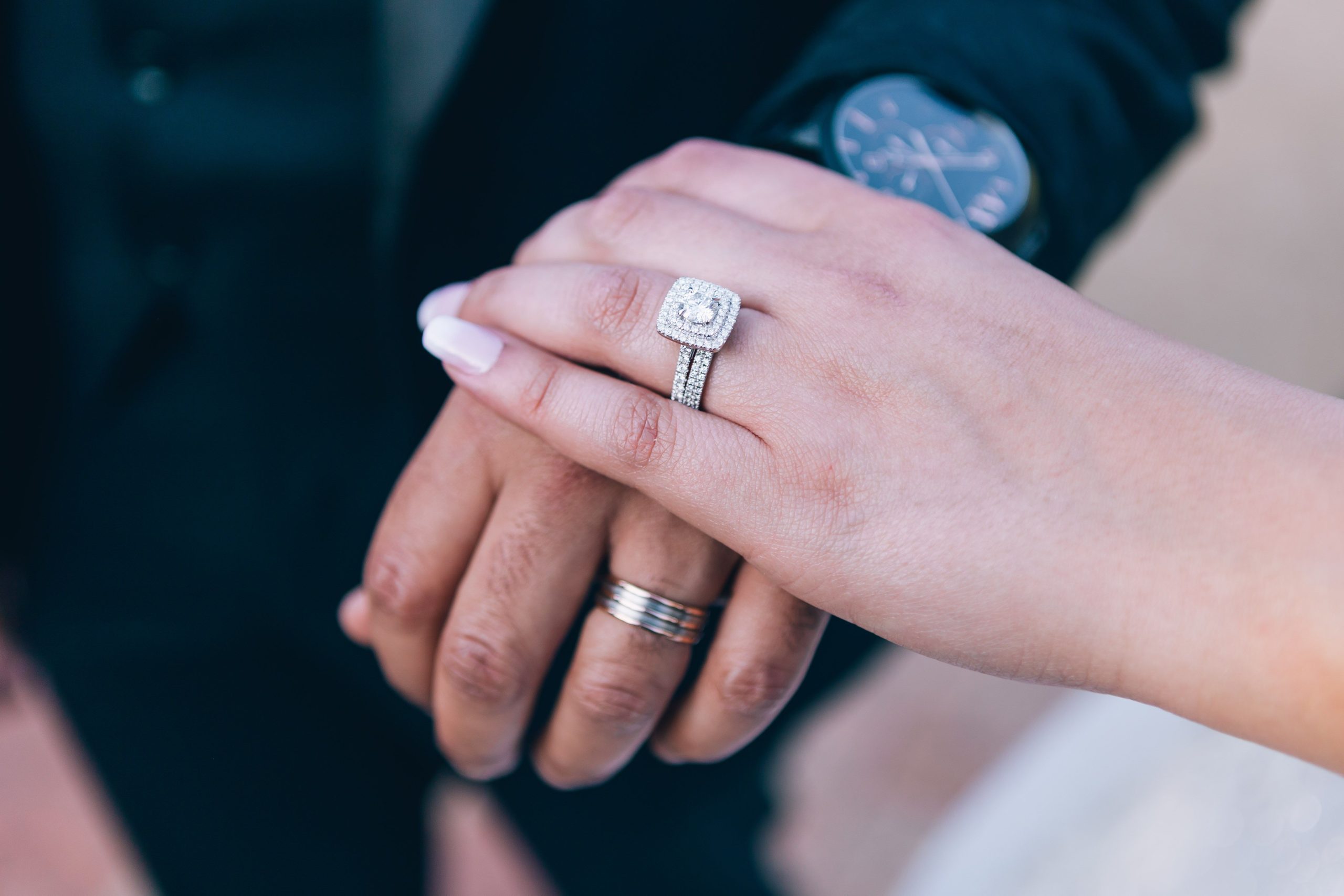 Mains avec bague de fiançailles et alliances en diamant