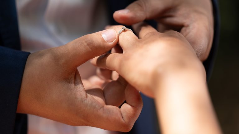 Bague glissée sur la main au soleil