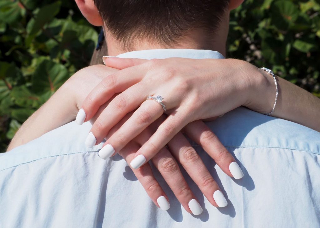 Couple enlacé avec une bague de fiançailles en diamant