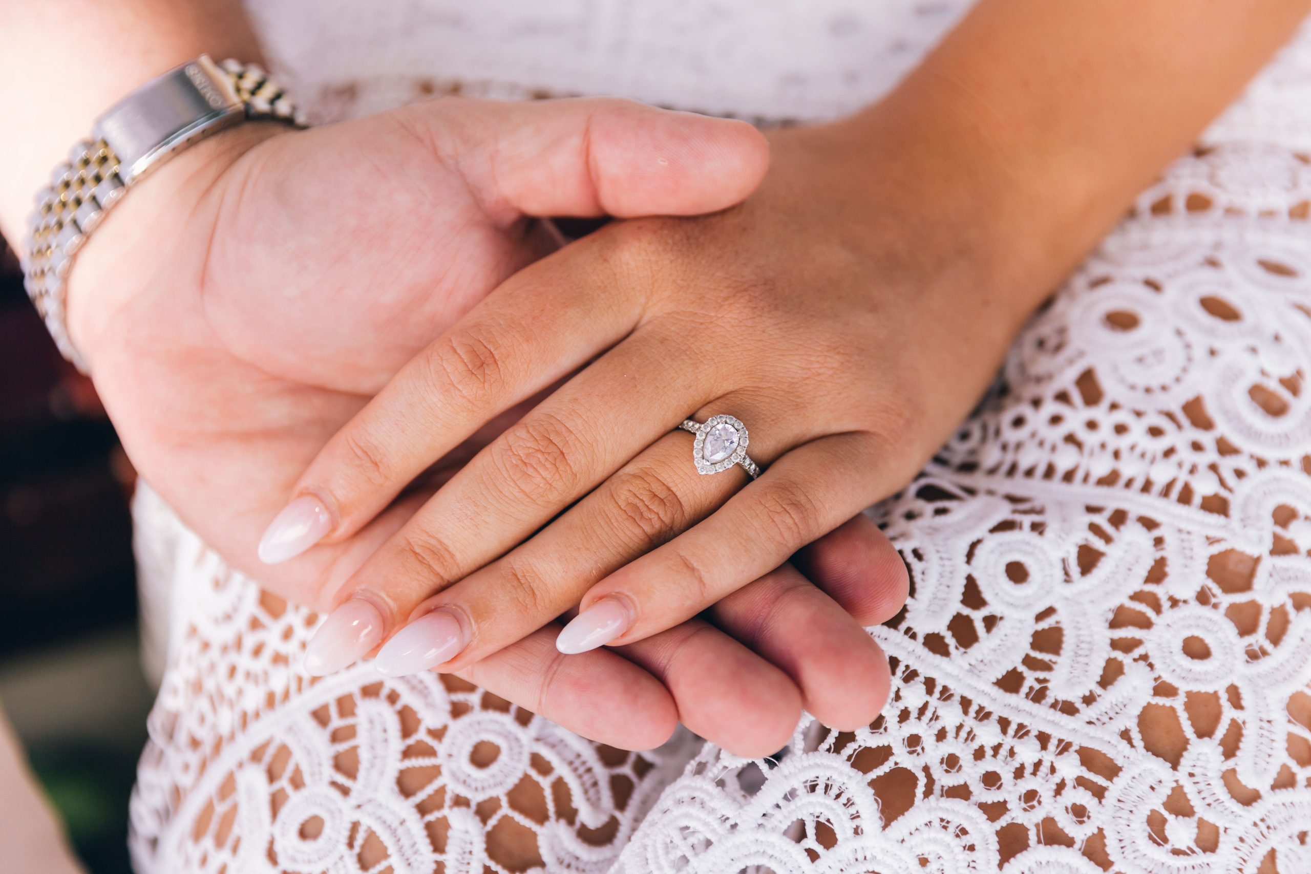 Mains d'un couple avec une bague de fiançailles en diamant