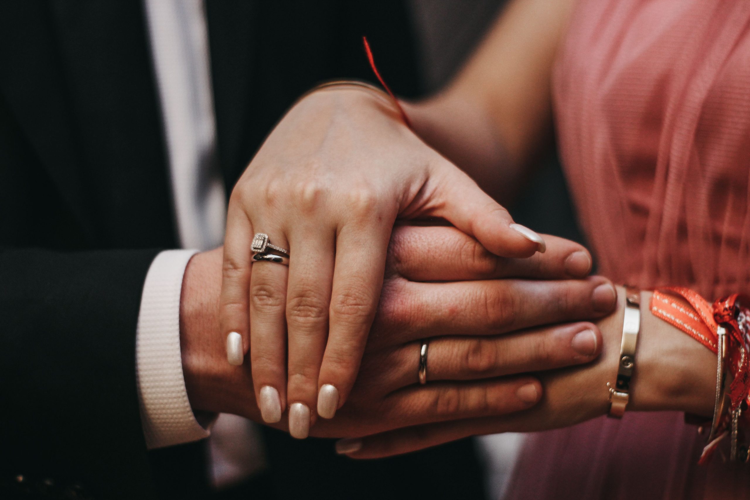 Mains d'un couple avec bagues de fiançailles