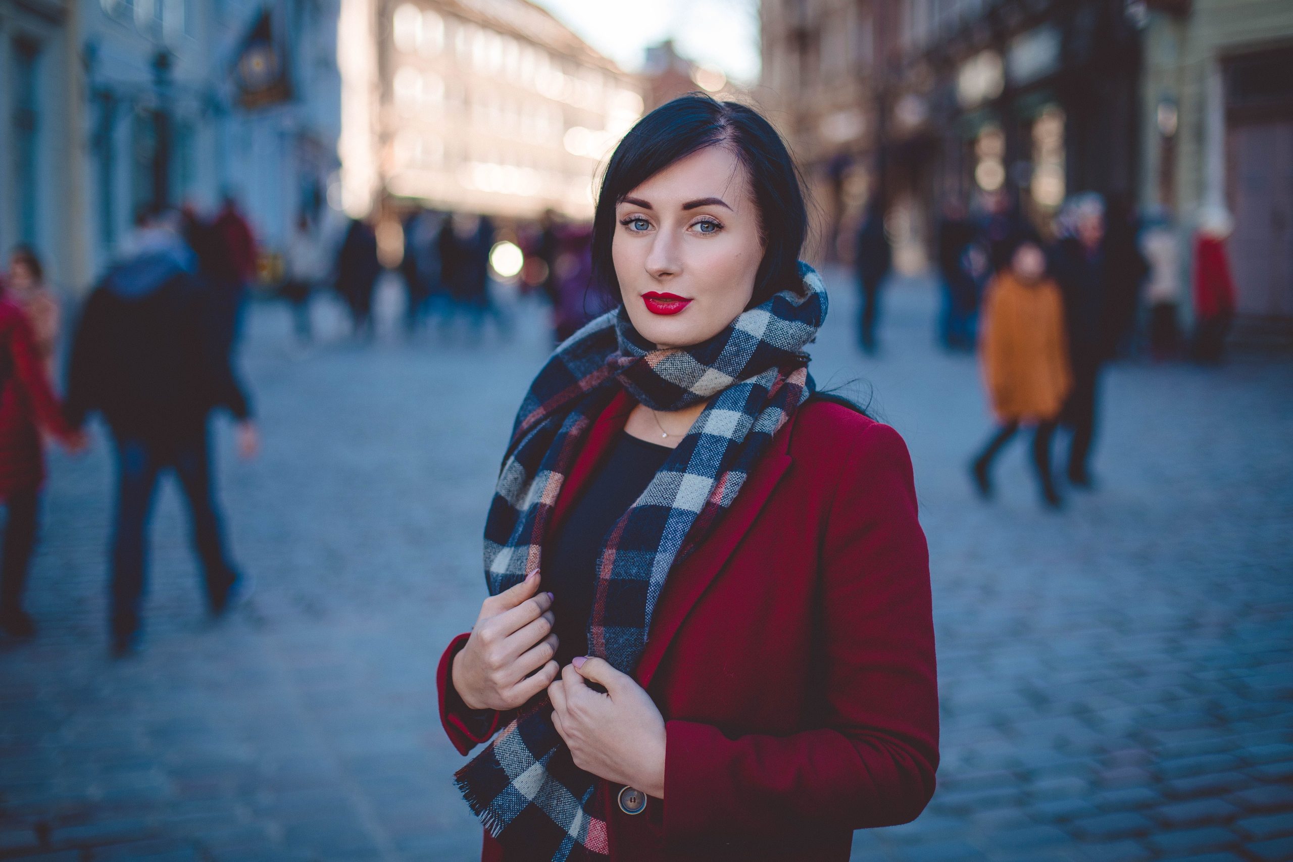 Femme en manteau rouge avec écharpe écossaise