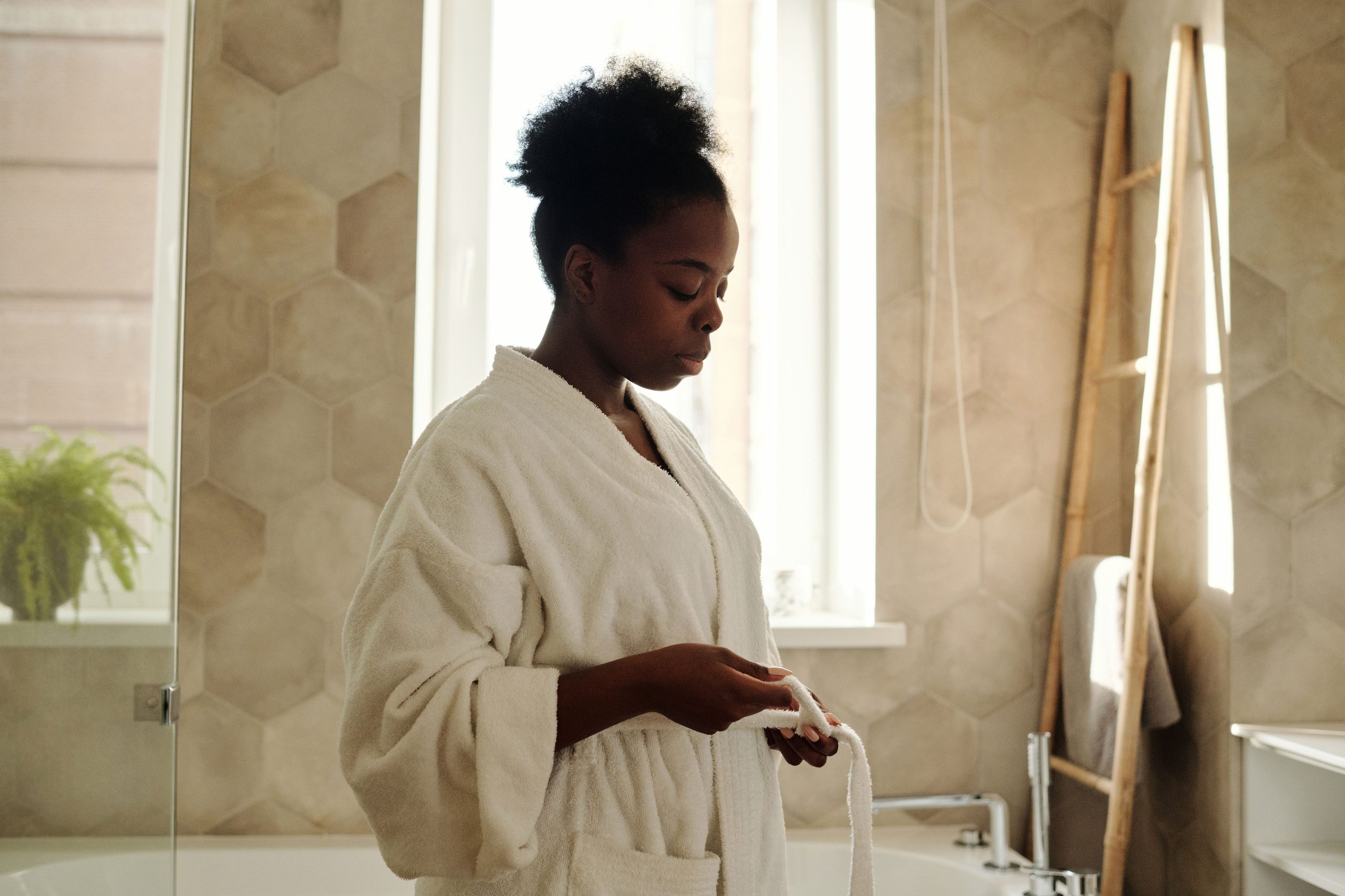 Femme en peignoir relaxant dans salle de bain