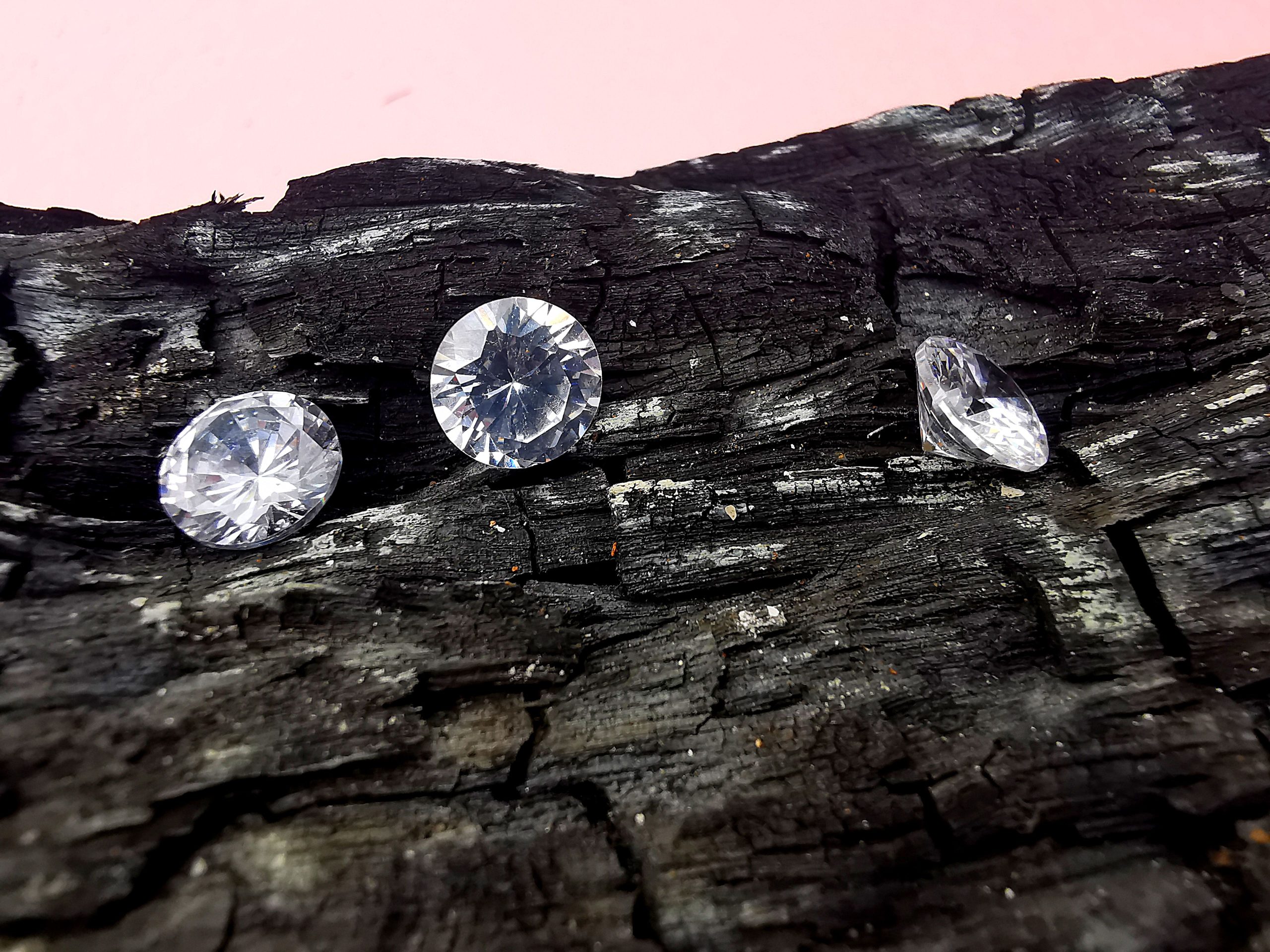 Trois diamants posés sur du charbon