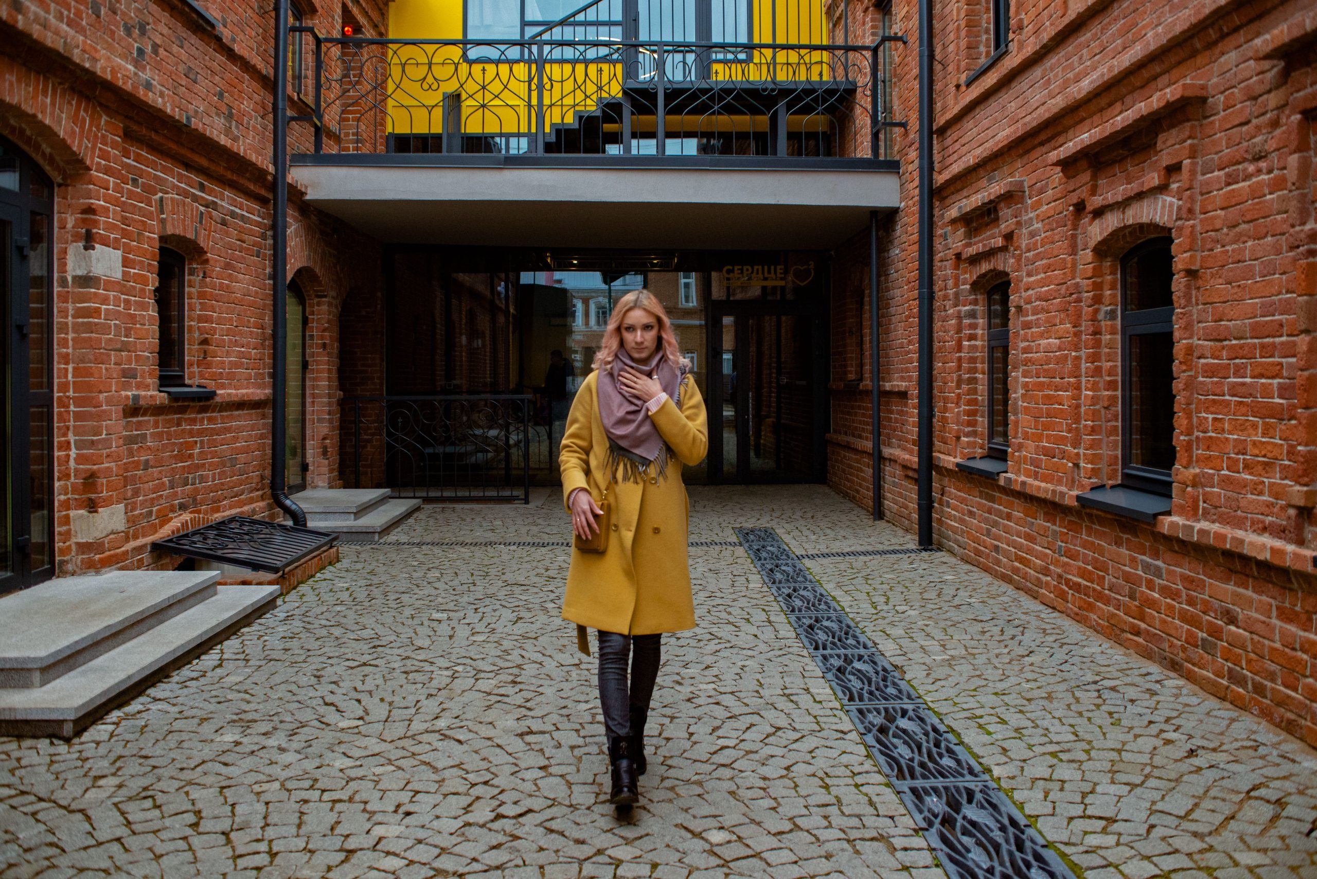 Femme stylée en manteau jaune et écharpe