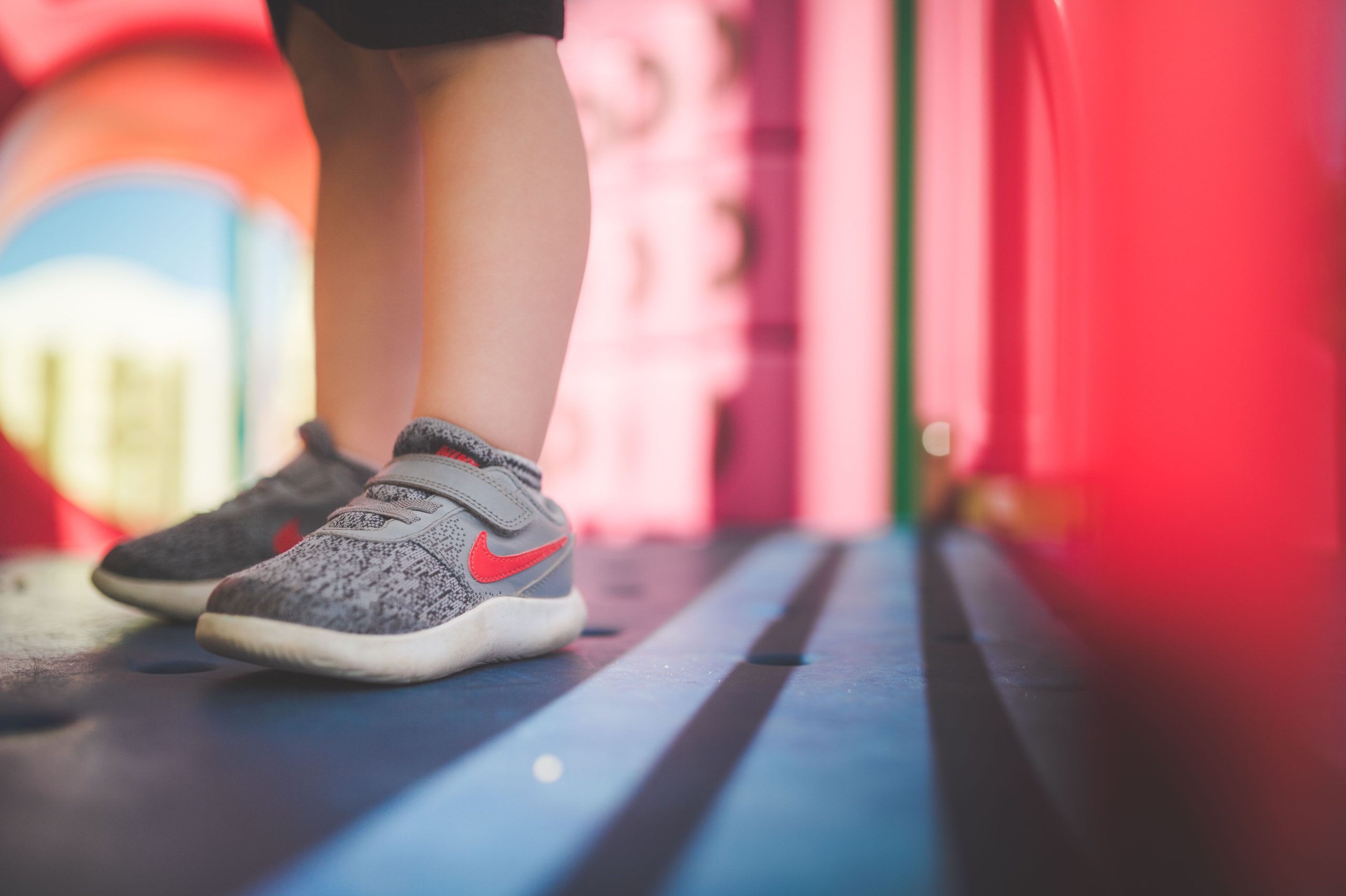 Pieds enfant chaussures grises terrain jeu coloré