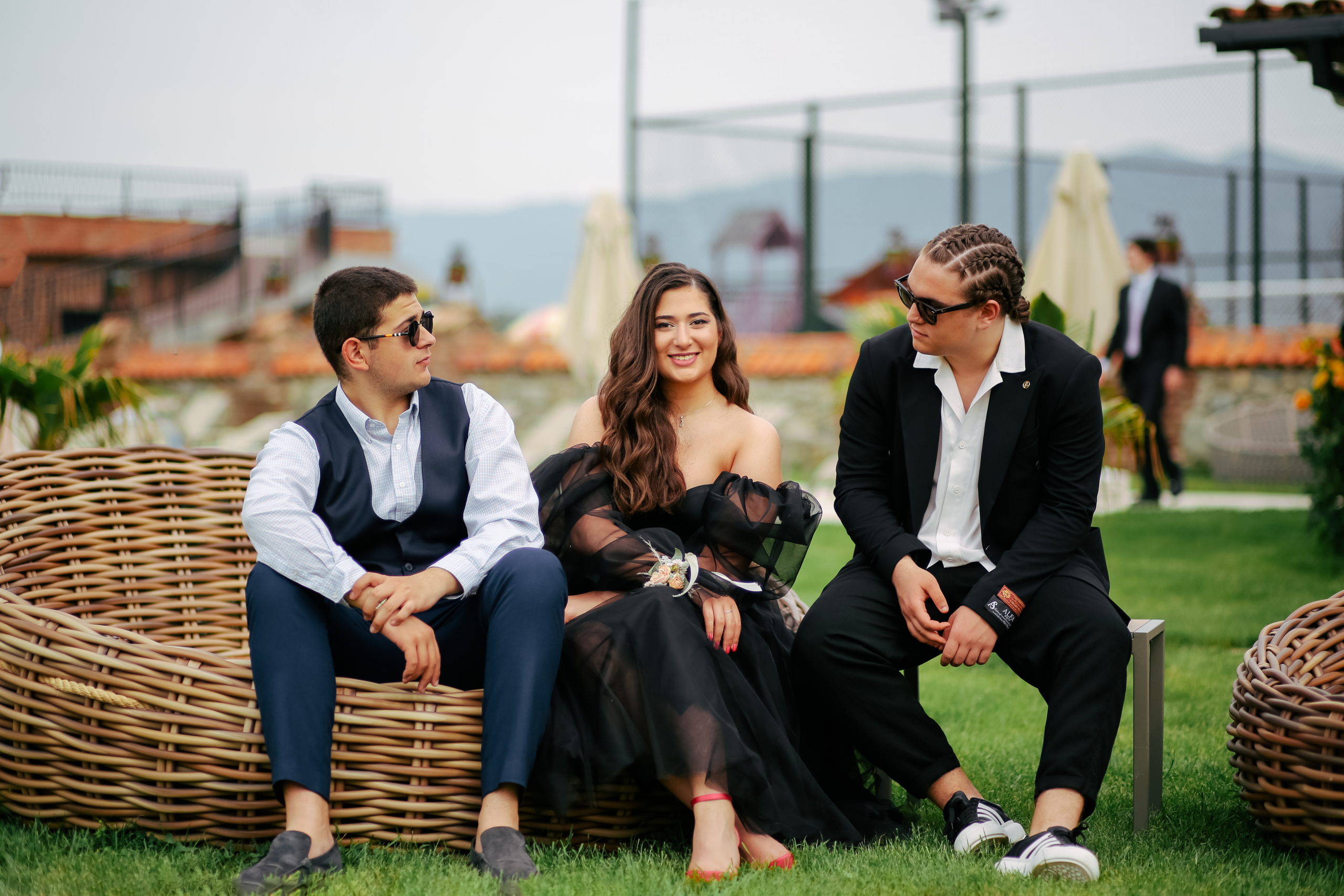 Trois personnes bien habillées assises à un mariage.