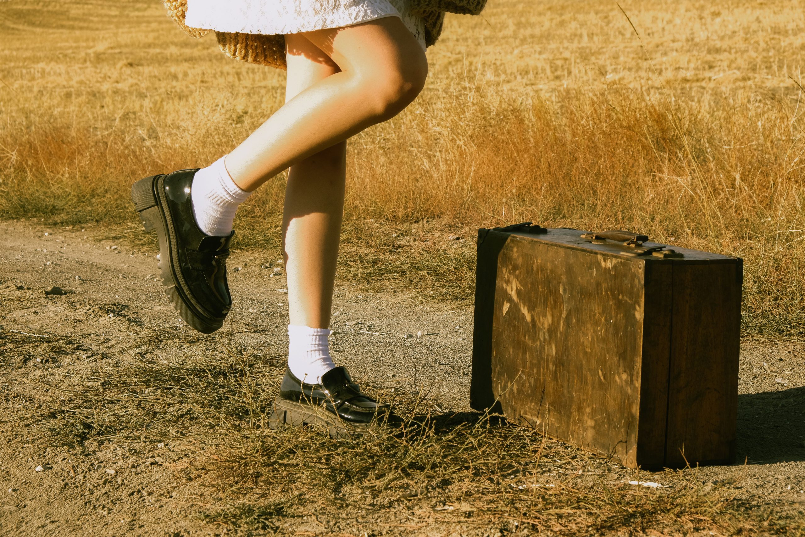 Femme en mocassins avec valise vintage rétro