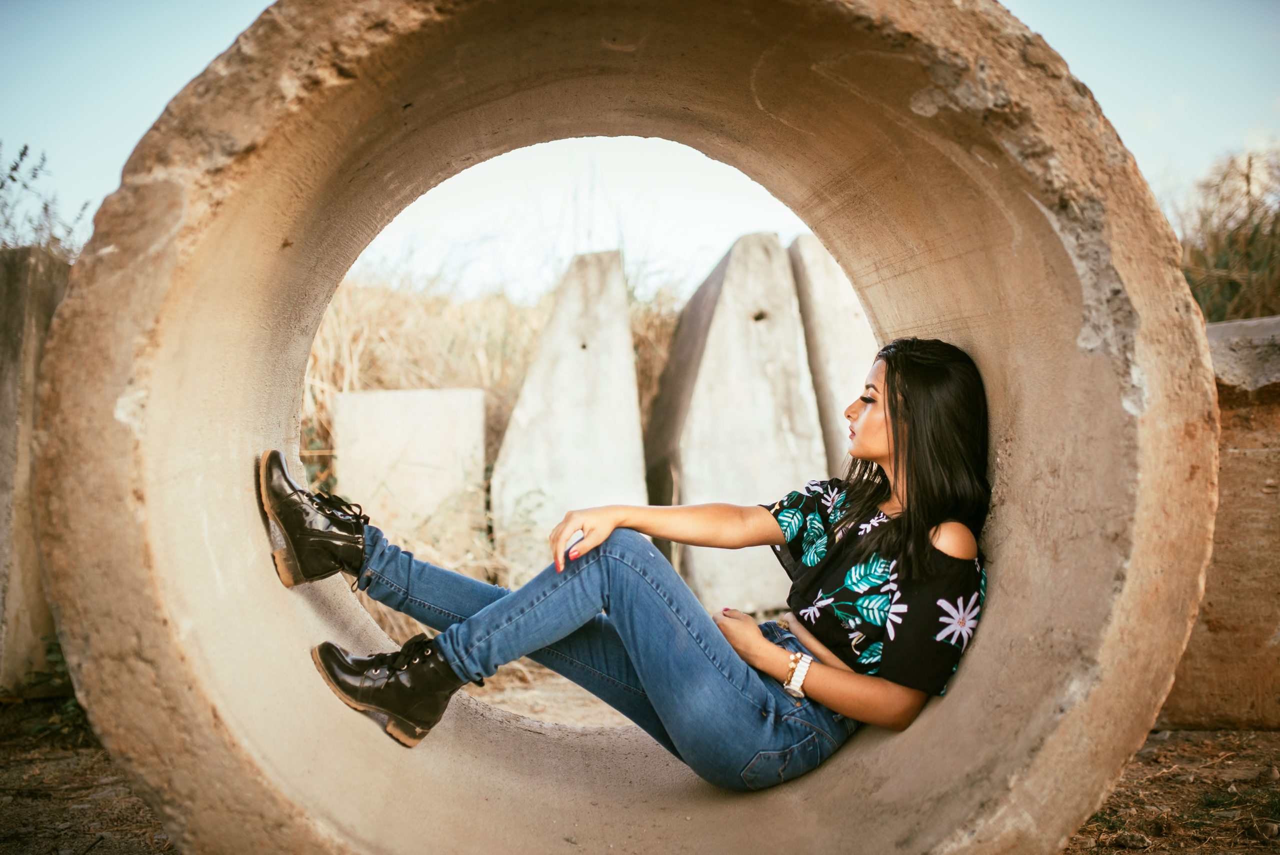 Femme en top fleuri et jean bootcut posant en plein air